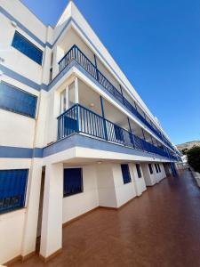 a large white building with blue balconies on it at Apartamento Morro de Gos Ref067 in Oropesa del Mar