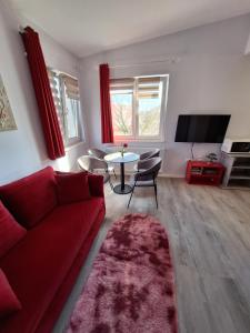 a living room with a red couch and a table at Villa Vino & Grad in Zagreb