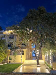a large yellow building with trees in front of it at Calm Pyramids View Villa in Cairo +87 photos