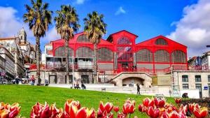 a large red building with palm trees in front of it at Dolce Vita Heroismo in Porto