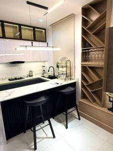 a kitchen with a sink and two bar stools at Cosmos in Lagos