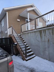 a stairway leading to a house with snow on the ground at Appartement de 2 chambre à la baie in Saguenay