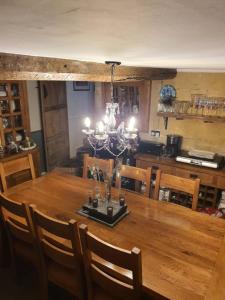 a dining room with a wooden table with a chandelier at Lamb Cottage Bed and Breakfast in Box
