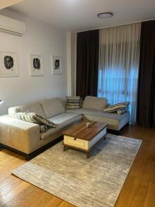 a living room with two couches and a coffee table at Skyline Residence Podgorica in Podgorica