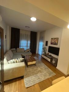 a living room with a couch and a table at Skyline Residence Podgorica in Podgorica