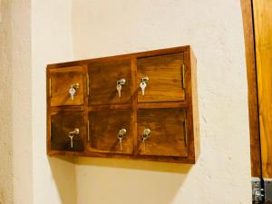 a wooden cabinet with keys on a wall at OM Inn in Trincomalee