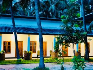 a building with palm trees in front of it at OM Inn in Trincomalee
