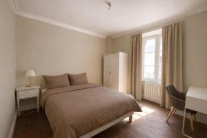 a bedroom with a bed and a desk and a window at Les volets verts in Pont-Croix +8 photos