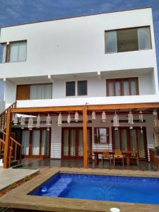 a villa with a swimming pool in front of a house at Surfers Paradise - Casa Caro in Punta Negra