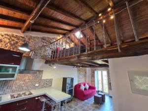 a living room with a red chair and a kitchen at Loft Naevio in Ferentino