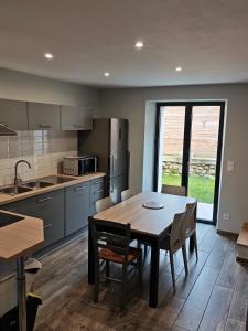 a kitchen and dining room with a table and chairs at Duplex climatisé in Aramits