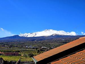 a snow covered mountain in the distance with a roof at A Casa di Nonna in Riposto