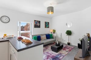 a kitchen and living room with a couch and a table at Spacious 1-Bed - Town Centre - Free Parking in Warrington