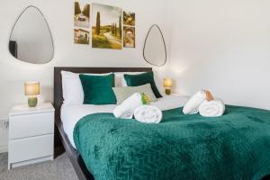 a bedroom with a green bed with towels on it at Spacious 1-Bed - Town Centre - Free Parking in Warrington