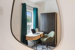 a mirror reflecting a room with a desk and a chair at Spacious 1-Bed - Town Centre - Free Parking in Warrington +19 photos