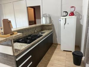 a kitchen with a stove and a refrigerator at Chácara pontarolo in Guarapuava