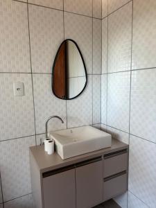 a white bathroom with a sink and a mirror at Chácara pontarolo in Guarapuava +15 photos