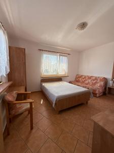 a bedroom with a bed and a couch at Dom Wczasowy Mateusz in Rewal +8 photos
