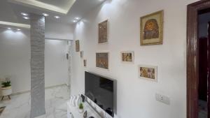 a white living room with a fireplace and a tv at Casa Pyramids View in Cairo