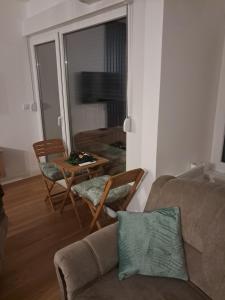 a living room with a couch and a table and chairs at Apartman Mihajlo in Divčibare