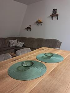 two green plates sitting on a wooden table at Apartman Mihajlo in Divčibare