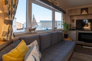 a living room with a couch and a large window at B3 Sunny Tides in Brixham