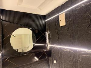 a bathroom with a mirror on a black wall at De Rex Luxury Apartment in Akwa