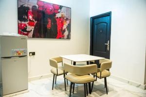 a dining room with a table and chairs and a refrigerator at De Rex Luxury Apartment in Akwa +15 photos