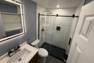 a bathroom with a shower and a toilet and a sink at Signature Suite in Orlando