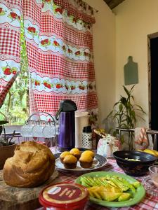 a table with bread and vegetables on a table at Camping Místico - Vale do Ribeira in Juquiá