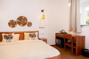 a bedroom with a bed and a wooden desk at OMNYA Nungwi Boutique Hotel in Nungwi +36 photos