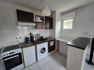 a small kitchen with a washer and dryer in it at T2 Confort - Clim, Piscine & Parking privé in Montauban +1 photo