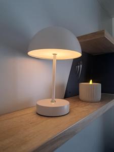 a lamp on a shelf with a candle on it at Chez Achille in Marcilly-sur-Eure