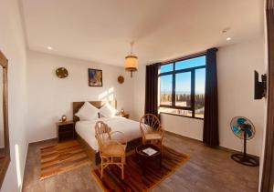 a bedroom with a bed and a large window at Dar Ayman Essaouira in Essaouira