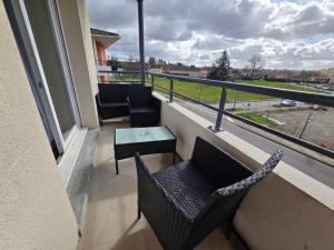 a balcony with chairs and a table and a view at T2 Confort - Clim, Piscine & Parking privé in Montauban