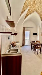 a kitchen with a sink and a table at Corte della Luce in Ugento +42 photos