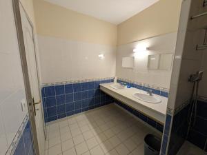 a bathroom with two sinks and blue and white tiles at Gîte de Navarre in Billy