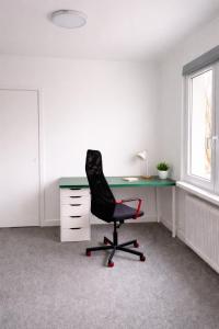 an office with a black chair and a desk at Stilla Hem 2 in Tranemo