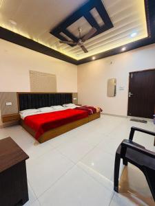 a bedroom with a large bed with a red blanket at Grihalaxmi Paying Guest House in Varanasi