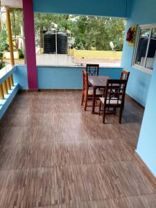 a dining room with a table and chairs on a deck at Vibheeshan Villa in Yelagiri