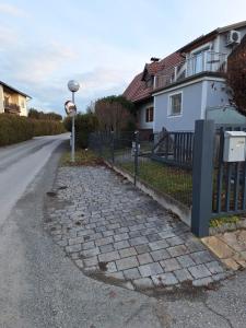 a street sign next to a fence and a house at Ferienhaus am Wildbachberg - Platz für die ganze Familie in Deutschlandsberg