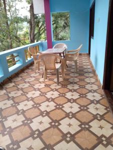 a balcony with a table and chairs on a tiled floor at Vibheeshan Villa in Yelagiri +27 photos