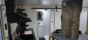a kitchen with a tree in the middle of a room at The Orchard's Nook Treehouse in Cottenham