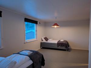 ein Zimmer mit zwei Betten und einem Fenster in der Unterkunft Aurora Fjord View Escape Narvik garden sleeps 10 in Narvik