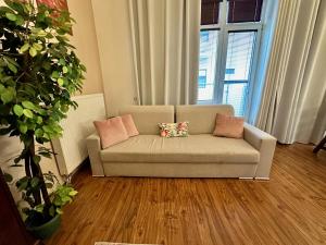 a couch with two pillows in a living room at Home Away main square apartment - sleeps 6 - AC - Balcony - Coffee Machine - Washer - Kitchen - Parking in Poprad +29 photos