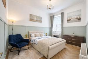 a bedroom with a bed and a blue chair at The Barony Fox in Edinburgh