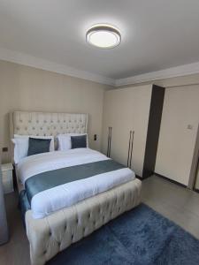 a bedroom with a large bed with a tufted headboard at joy in Nairobi