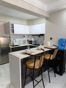 a kitchen with two bar stools and a counter top at joy in Nairobi +4 photos