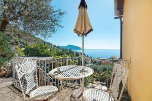 a table and chairs on a balcony with an umbrella at Agriturismo Le Pale in Bogliasco