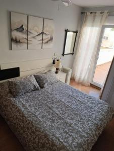 a bedroom with a bed and a large window at Loft con encanto de Raúl y Rosa in San Sebastián de los Reyes